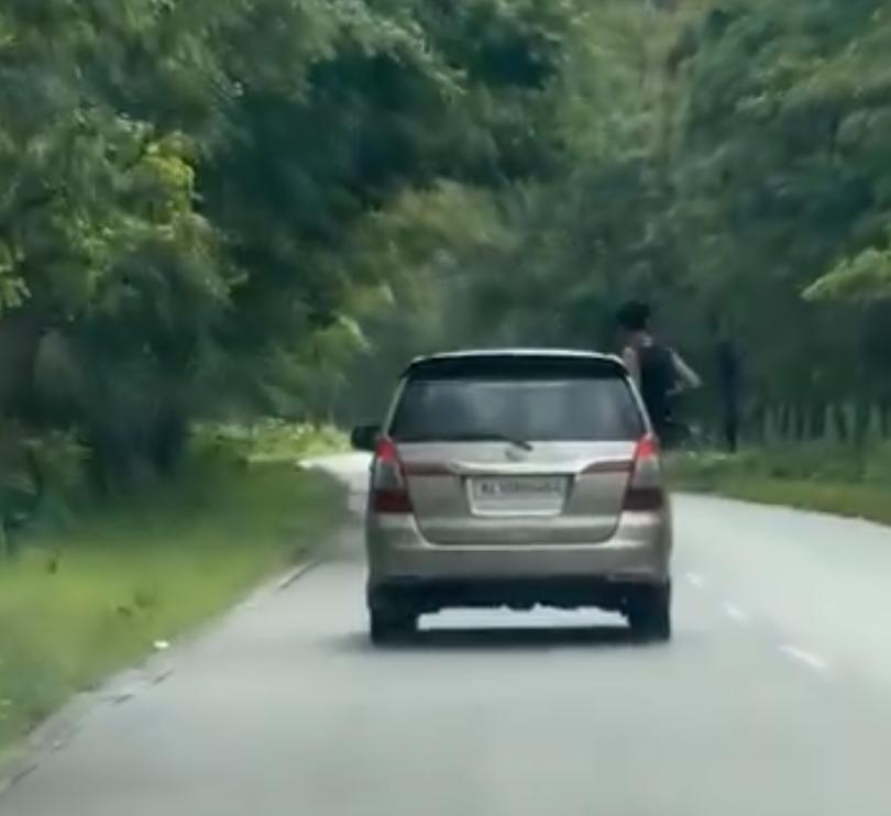 കാറിന്റെ ഡോറിലിരുന്ന് യുവാവിന്റെ സാഹസിക യാത്ര